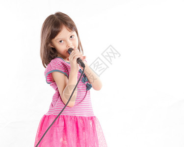 美丽的亚洲女童用麦克风歌唱的亚洲女童技术歌手图片