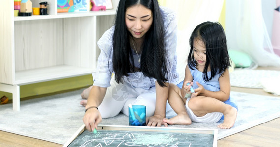 妈妈孩子插画家有创造力的成人幸福亚洲母亲和女儿一起涂油漆背景