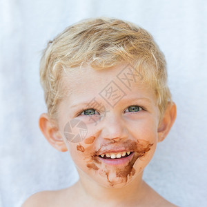 美丽的头发男孩肖像脸上有巧克力孤立在白色背景上婴儿男孩笑容和照片白色的金发快乐图片