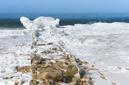 支撑富有表现力的岩石冬季积水在雪中波罗的海冰中雪沙滩图片