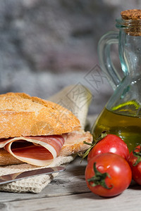 盘子治愈红色的Iberico火腿三明治和自制面包在木烤炉中图片