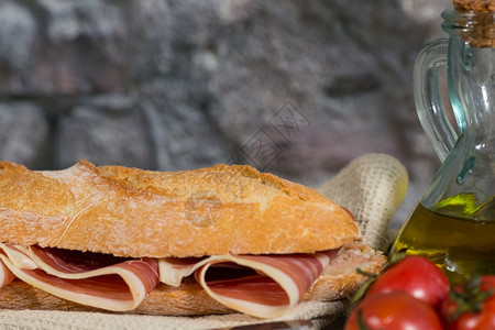 Iberico火腿三明治和自制面包在木烤炉中塞拉诺典型的番茄图片