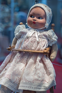 长椅玩具娃头戴白帽的复古娃坐在木制高脚椅上头戴白帽的复古娃坐在木制高脚椅上童年图片