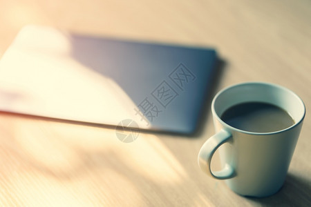 工作桌用笔记本电脑一杯咖啡清晨阳光古典风格咖啡店优质的早晨图片