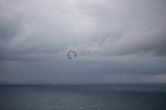 黑色的激烈海洋背景有雨云海洋背景地平线上有云和雨多的图片