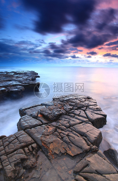黄昏海岸线的美丽岩石图片