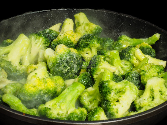 在煎锅里吃冷冻的绿花椰菜植物化学质蒸熟一顿饭图片