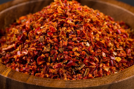 胡椒白色背景的木碗中粉碎红辣椒有质感的粉末图片