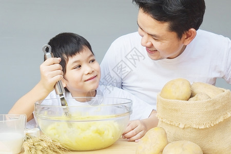 食物制造爸和儿子做马铃薯泥开心地做土豆泥亚洲人图片