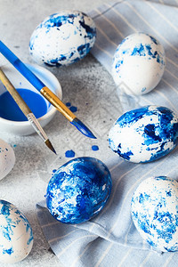 春天灰色背景的蓝斑点东方鸡蛋配有油漆和刷子装饰鸡蛋为复活节做准备为复活节知更鸟白色的图片