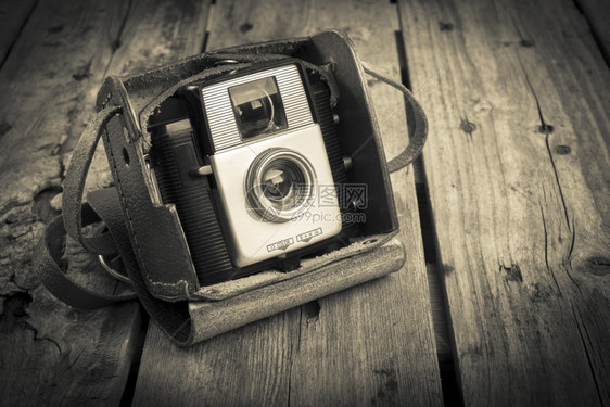 垃圾摇滚原来的旧皮革案相机在木制背景过滤器上被电影图片