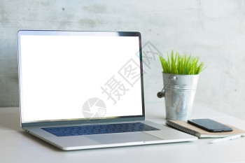 工作桌上显示白空屏幕的工作台膝上型计算机阁楼工作场所装饰风格图片