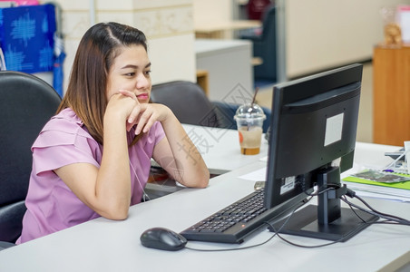 年轻的沟通随意亚裔妇女在办公室从事计算机工作的妇女图片