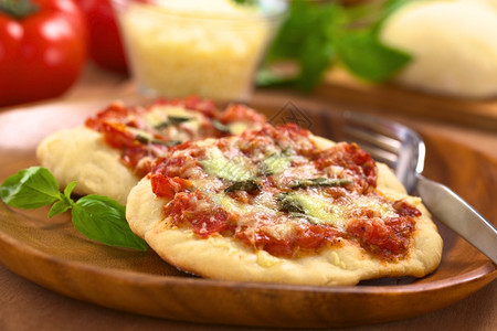 第一的意大利Crispy家制披萨玛格瑞塔或莫扎里拉比配有番茄巴西尔和奶酪在木板上加叉子其中成分在后面选择焦点中第一张披萨玛格瑞塔图片