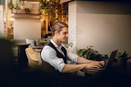 在职的积极线创意工作空间或咖啡厅从事计算机笔记本电脑工作的笑脸商人图片