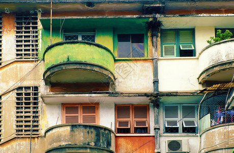 高的赛在越南胡志明市古老建筑的董公寓旧木窗和房子周围的阳台绿色和红是令人惊叹的外表颜色对比鲜明的建筑物优质图片