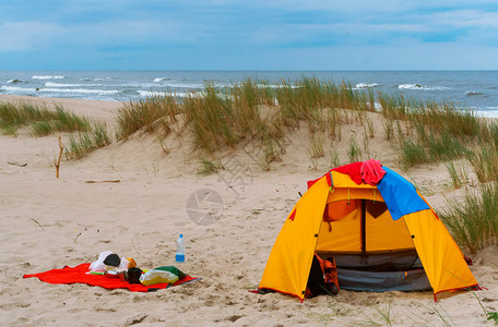 海滩洋空的沙上黄色旅游帐篷沙滩上的和东西沙滩上的帐篷和东西黄色的旅游帐篷图片