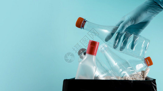 矿物生态将废旧塑料瓶扔入垃圾回收再循环和零废物运动境概念关爱项目中与清洁手套携把废旧塑料瓶丢入垃圾回收再循环和零废物运动放图片