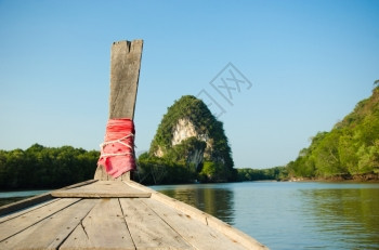 亚洲人木头传统制船对抗热带河其背景是Krabi标志KhaoKanabNam悬崖泰国克拉比镇亚洲图片
