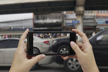 车辆司机受伤手持智能机在车祸现场拍照为保险事故而发生车祸的现场拍摄图片