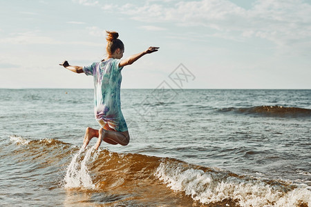 享受海浪的女孩在暑假期间日落时分海滩上度过空闲时间享受海浪的女孩在暑假期间海滩上度过空闲时间幸福自由溅起图片