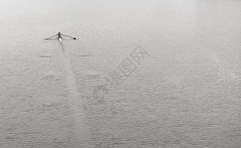 在冷水表面的平静上划船单人运动独行滑雪努力河强的图片