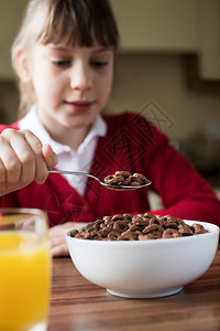 老的甜在室内女孩穿衣学校统一食糖早餐饭碗厨房的谷类食品图片