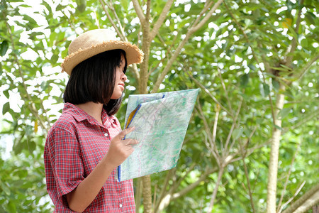 游客信息在户外自然背景旅行春季暑假概念GenZ等地站立在野外自然背景旅行春天暑假概念中时持有的年轻亚洲女孩旅行者肖像冒险图片