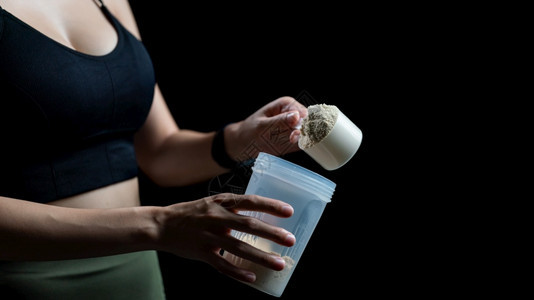 补充近距离接女测量一勺威氏蛋白质和摇晃瓶制作蛋白奶昔舀锻炼图片