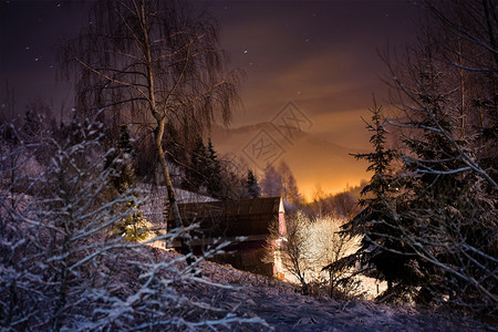 北风景山中冬季森林的灯火通明房子冬季森林中的灯火通明房子场景图片