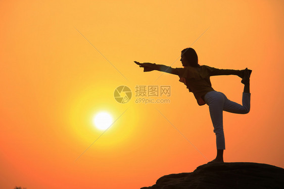 夕阳下做瑜伽的女性剪影图片