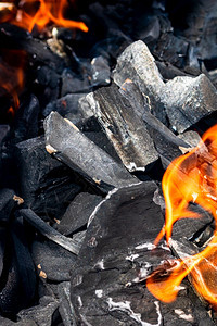 烧烤炉坑充满发光和燃烧的烈火红热炭砖和焚化炉黑色的易燃牛扒图片
