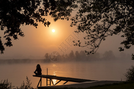 日落时女子在码头休息图片