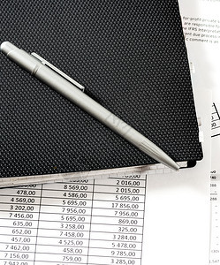 成功带有财务表格和文件的上一张黑纸条的银笔面有财务表格和单据财务表格注纸和桌子上的笔图表一种图片
