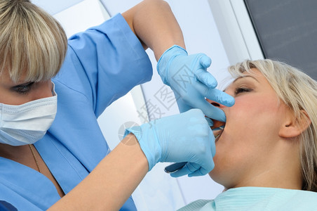 给病人治疗牙齿的牙科医生图片