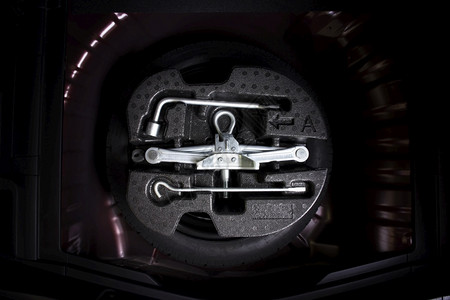 空闲的安全汽车零件概念备用轮胎中的和式换工具箱拧紧图片