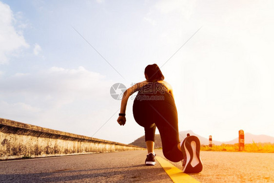鞋准备就绪女跑步者在起位置上站立并长途奔跑追踪图片