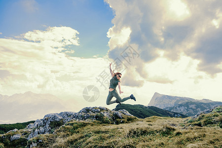 自然移动年轻妇女在山上跳跃旅行图片