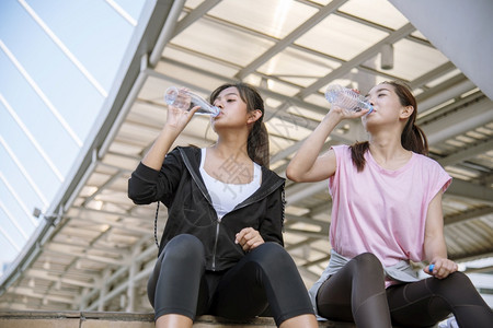 跑步女在运动后饮用现代城市的矿泉水在年轻女户外锻炼时身穿健康运动服并超越健康生活方式的女概念在健康生活方式之外进行户锻炼赛跑者现图片