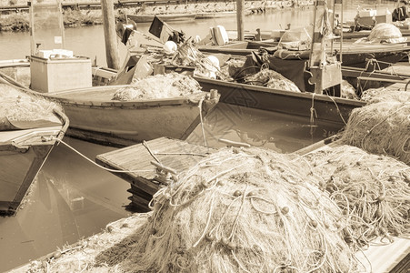 海岸抓住鱼船背景中在码头上使用老式渔网效应船充满活力图片