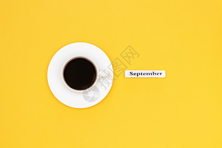 高架一杯黑咖啡和黄色背景上的九月文字复制空间平躺概念你好十一月咖啡杯和黄色背景上的九月文字情绪饮料图片