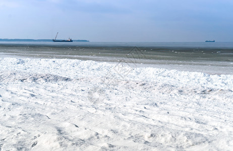 雪中的海岸船在地平线上桥海水图片
