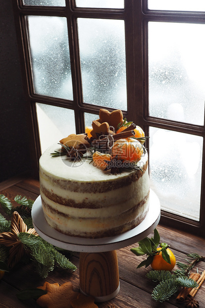 在窗帘橘子饼干和卷树枝的发光窗口附近一个摊子上高大蛋糕柑橘类冬天乡村图片