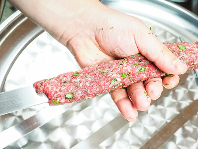 传统的一个厨师做红肉烤串和在金属盘上吃鱼的厨师食谱猪肉图片