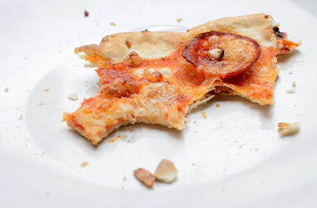 白色盘子上的腊肠披萨残骸遗迹热快速地图片