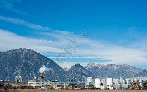 化学塔工厂业其背景为储油罐烟囱和阿尔卑斯山贮存图片
