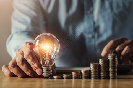 明亮的数字电持有光灯泡概念的商人手握具有创新和灵感思想金融会计图片