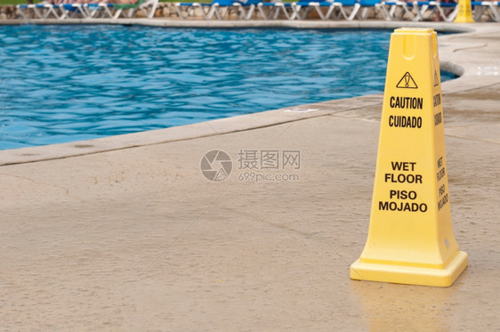 游泳池旁边滑地表面的黄色警示符号图片