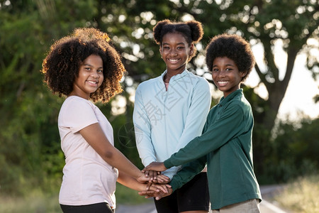 多种族一群平头儿童卷发双手堆叠非洲人统一背景