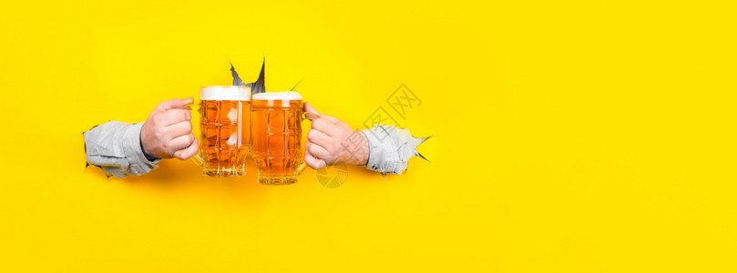 碰杯酒鬼黑暗的两啤酒放在手上黄色背面的连环眼镜上图片